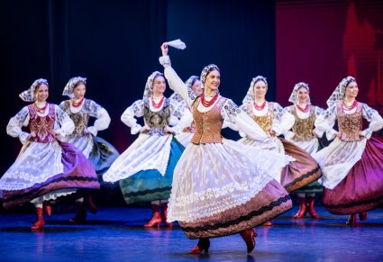 Tancerki w kostiumach wilanowskich na scenie w obrotach