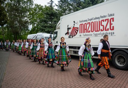 Artyści Zespołu "Mazowsze" w kostiumach łowickich na tle autokaru "Mazowsza"