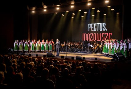 Zespół Pectus na scenie wraz z chórem zespołu Mazowsze w kostiumach kurpiowskich, widoczna widownia