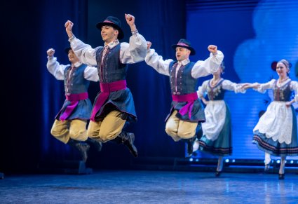 Tancerze w kostiumach kaszubskich podczas akrobacji tanecznych na scenie
