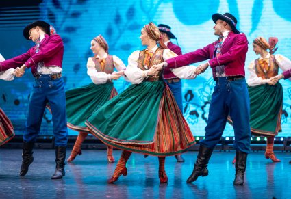 Artyści w kostiumach wilamowskich na scenie w figurach tanecznych