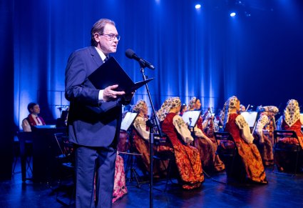 Przemówienia przed koncertem, w tle widoczna orkiestra