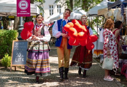 Trójka Artystów w kostiumach ludowych podczas rozdawania balonów na IX Pikniku Rodzinnym z Zespołem "Mazowsze"