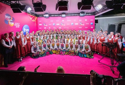 Chór w kostiumach łowickich, balet w kostiumach opoczyńskich i orkiestra w kostiumach wilanowskich podczas zdjecia na ściance festiwalowej