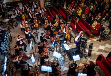 Zbliżenie na dyrygenta i orkiestrę podczas koncertu w Kościele pw. bł. Władysława z Gielniowa w Warszawie