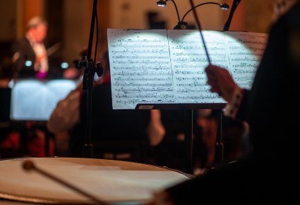 Zbliżenie na bęben z widocznym dyrygentem w tle podczas koncertu