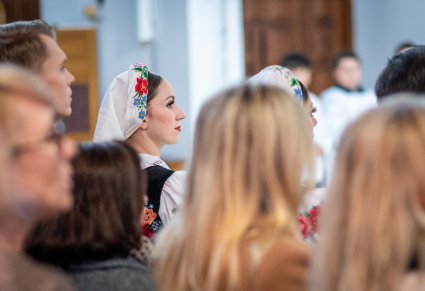 Zbliżenie na artystki w kostiumach łowickich na mszy