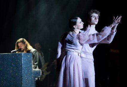 Para tancerzy podczas układu, w tle wokalista zespołu Pectus grający na pianinie