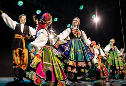 Zbliżenie na artystów w kostiumach łowickich
