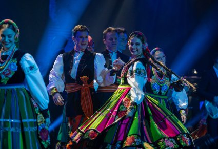 Zbliżenie na parę artystów w kostiumach łowickich, dziewczyna w obrocie