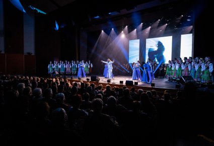 Wokalista zespołu Pectus na scenie wraz z chórem w kostiumach łowickich