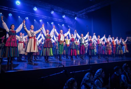 Grupa tancerzy w kostiumach opoczyńskich w ukłonach
