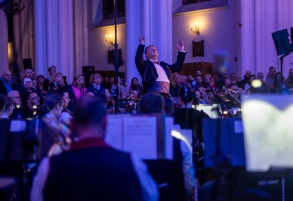 Dyrygent i orkiestra podczas koncertu na tle widowni