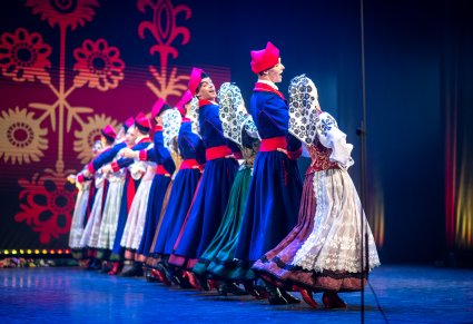 Grupa tancerzy w kostiumach wilanowskich w trakcie tańca na scenie