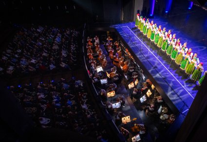 Chór i orkiestra Zespołu "Mazowsze" w kostiumach kurpiowskich przed publicznością w teatrze