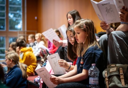 Dzieci ze śpiewnikami podczas warsztatów wokalnych