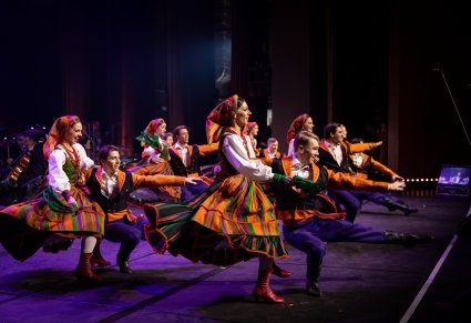 Tancerze w kostiumach sannickich w figurach tanecznych na scenie