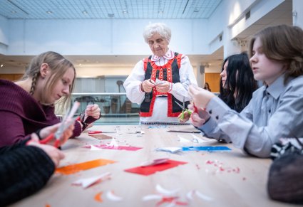 Twórczyni ludowa z dziećmi podczas warsztatów z wycinanki kurpiowskiej