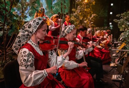 Zbliżenie na myzyków orkiestry, w kostiumach wilanowskich, grających na instrumentach smyczkowych