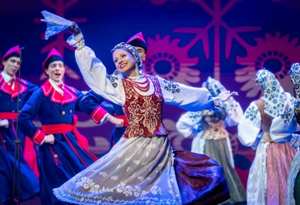 Zbliżenie na tancerkę w kostiumie wilanowskim, w tle widoczna reszta tancerzy