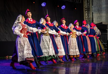 Grupa tancerzy w kostiumach wilanowskich na scenie