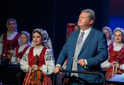 Zbliżenie na dyrygenta i orkiestrę