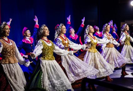 Grupa tancerzy w kostiumach wilamowskich na scenie
