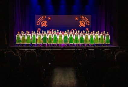 Chór w kostiumach kurpiowskich i widownia podczas koncertu