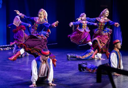 Grupa artystów w kostiumach podegrodzkich w figurach tanecznych