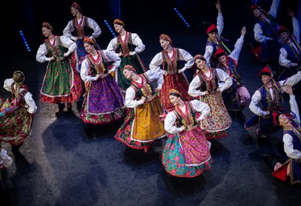 Grupa tancerek w kostiumach krakowskich na scenie