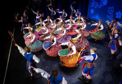 Grupa tancerzy w kostiumach krakowskich w figurze tanecznej