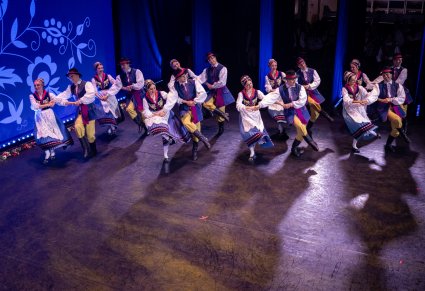 Grupa tancerzy w kostiumach kaszubskich wchodząca na scenę