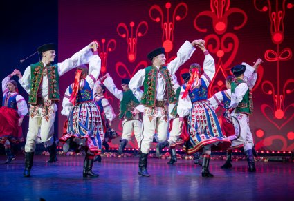 Grupa tancerzy w kostiumach spiskich na scenie