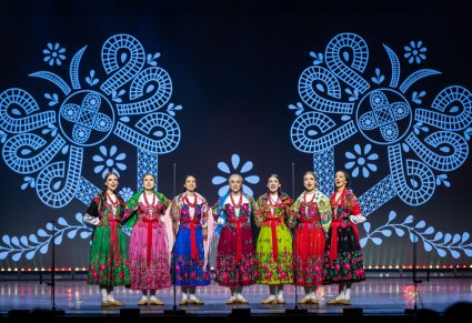 Artystki chóru w kostiumach podhalańskich wykonujące utwór na scenie