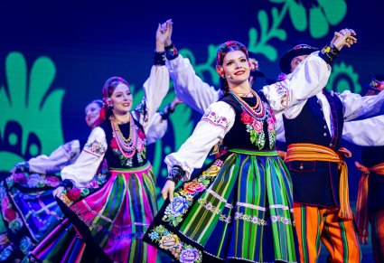 Zbliżenie na artystkę w kostiumie łowickim w układzie finałowym