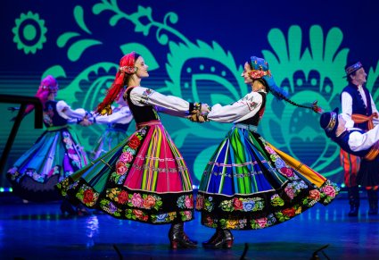 Zbliżenie na artystki w kostiumach łowickich w obrotach na scenie