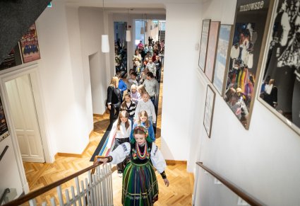 Zwiedzający ekspozycję w Centrum Folkloru Polskiego "Karolin" z oprowadzającą w kostiumie łowickim