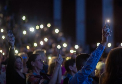 Widownia podczas koncertu z zapalonymi światełkami