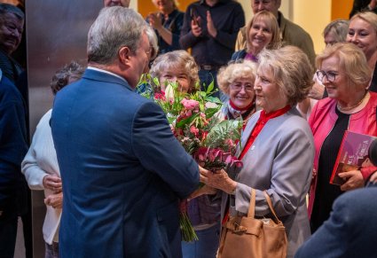 Dyrektor wręczający kwiaty Irenie Santor