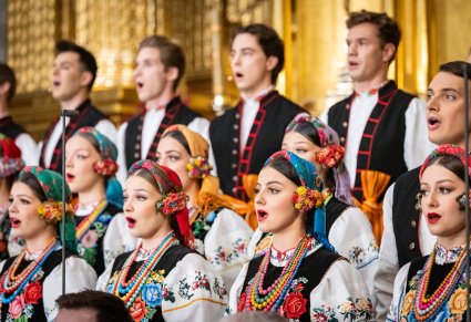 Zbliżenie na Artystów Chóru w kostiumach łowickich podczas śpiewu