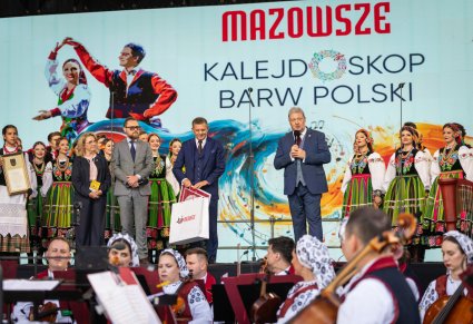 Dyrektor zespołu "Mazowsze" wraz z merem rejonu solecznickiego oraz przedstawiciele Samorządu Województwa Mazowieckiego, w tle część Artystów w kostiumach łowickich