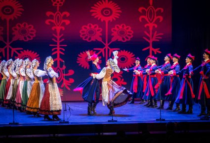 Grupa tancerzy w kostiumach wilanowskich w trakcie tańca na scenie