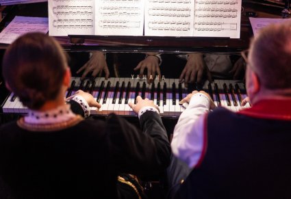 Para artystów orkiestry grająca na klawiszach podczas koncertu