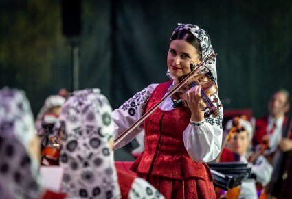 Zbliżenie na Skrzypaczkę grającą na skrzypcach, ubraną w kostium wilanowski