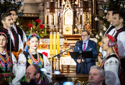 Przemowa otwierająca koncert, po bokach widoczny chór
