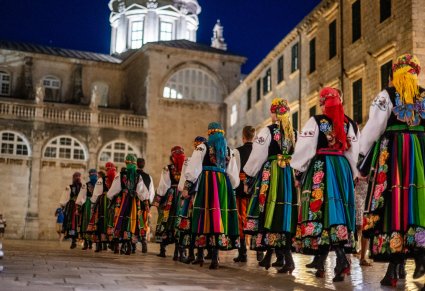 Artyści w parach w kostiumach łowickich na dziedzińcu