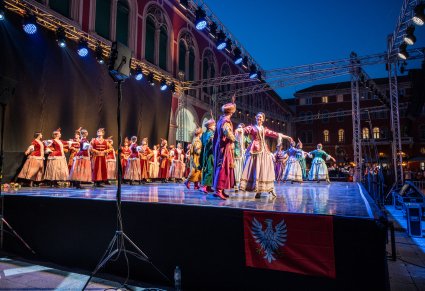 Artyści na scenie wykonujący choreografię taneczną w kontuszach