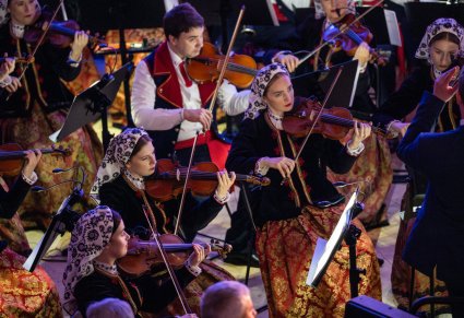 Zbliżenie na osoby grające na skrzypcach podczas koncertu