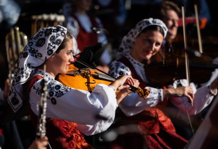Muzycy grający na instrumentach smyczkowych, podczas koncertu na scenie