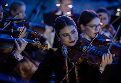 Zbliżenie na artystkę grającą na skrzypcach